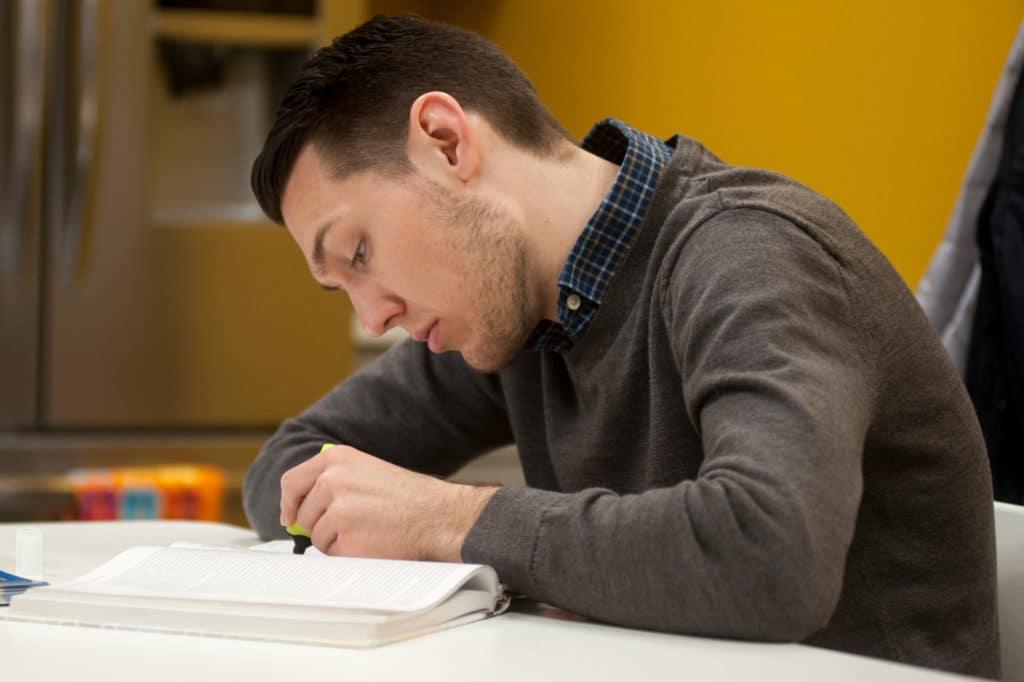 Student studying, reading a textbook.